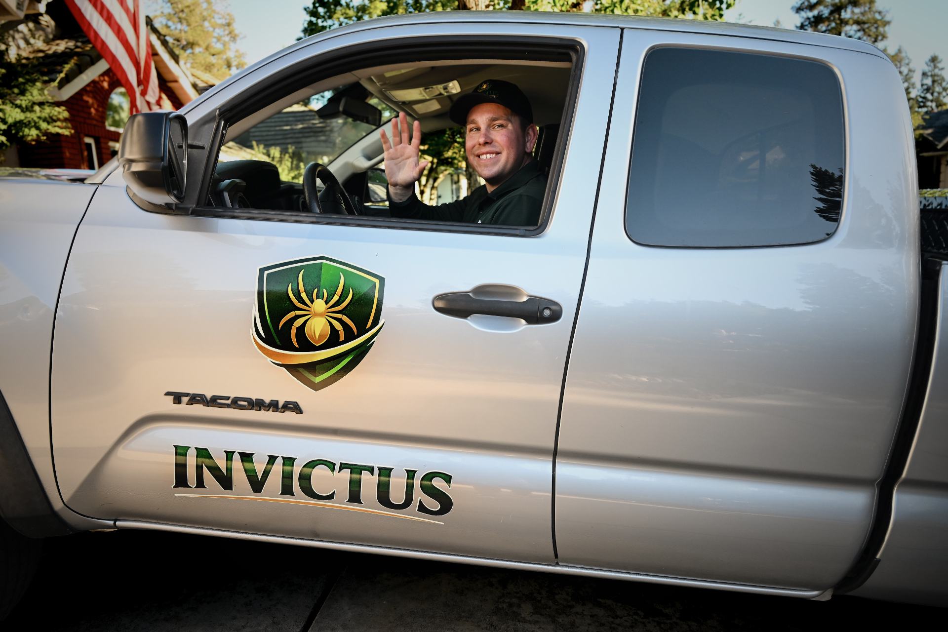 Invictus Pest Management technician waving from a service truck